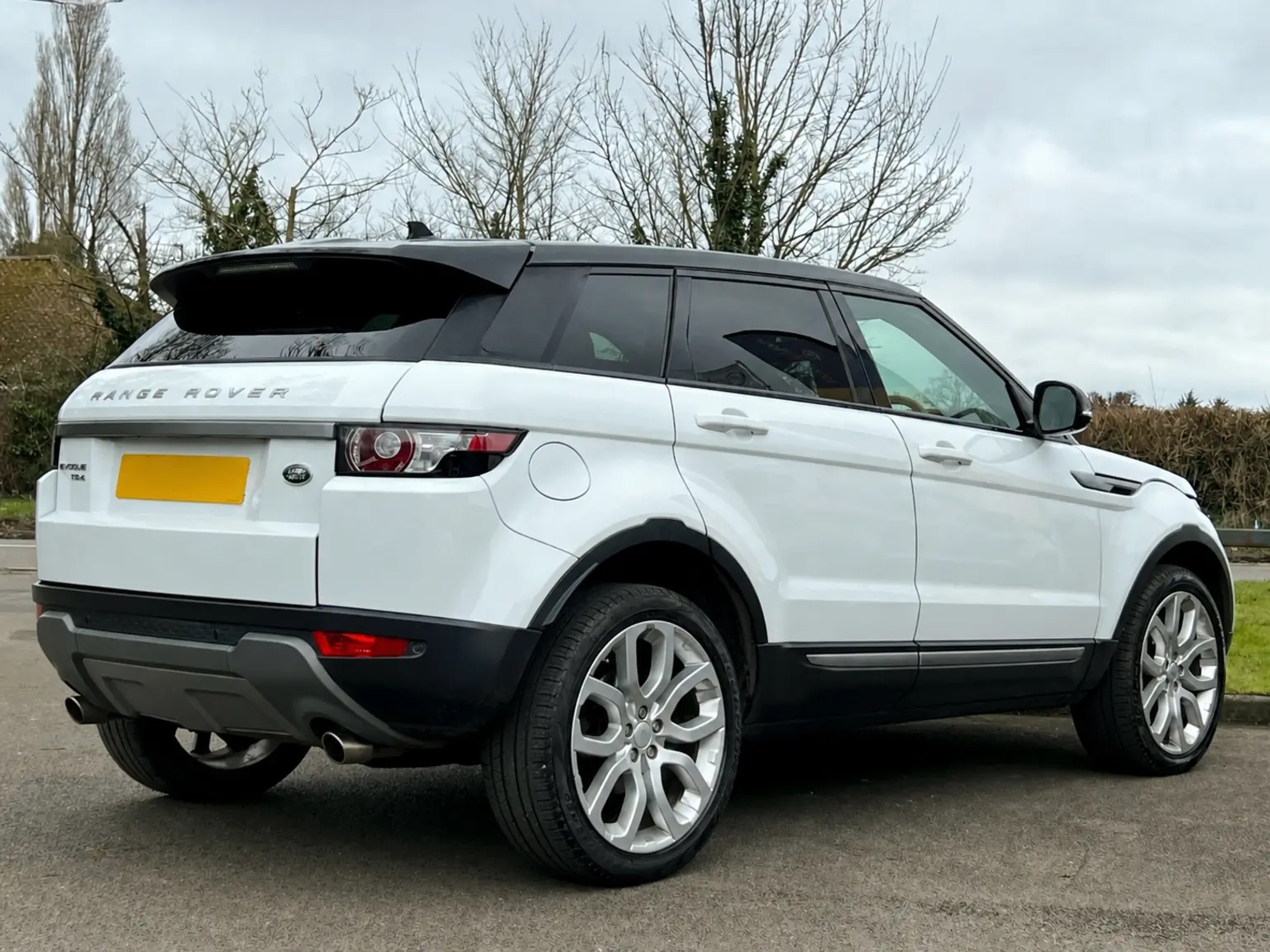 White Range Rover Evoque photographed from the rear three-quarter angle with its registration removed